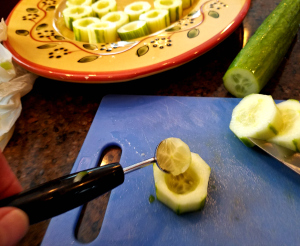 scooping center out of cucumbers to make cups